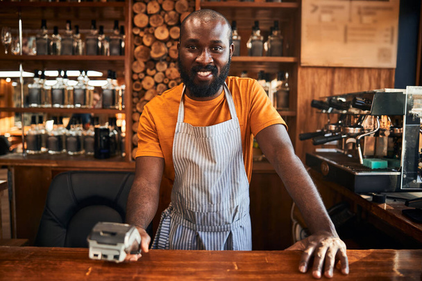animada masculino barman segurando terminal para pagamento sem contato - Foto, Imagem