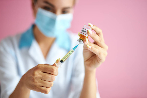 close-up photo of female doctor filling the syringe with vaccine - 写真・画像