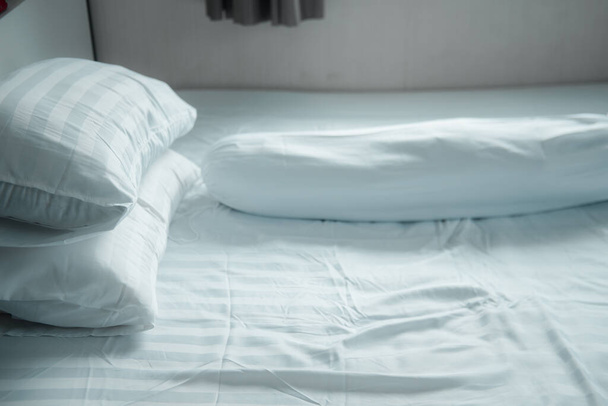 Sluiten up wit kussen en bolster op wit bed in huis - Foto, afbeelding