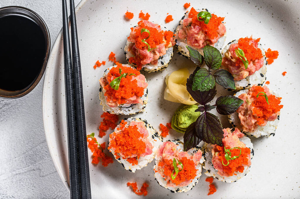 Sushi tekercs avokádóval, tonhallal, lazaccal és kaviárral. Szürke háttér. Felülnézet. - Fotó, kép