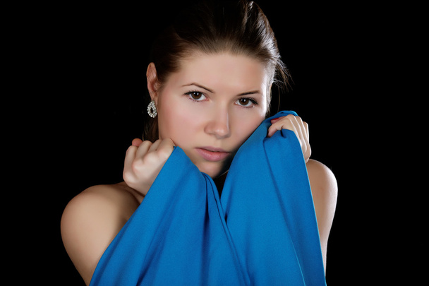 Portrait of the girl  wrapped up dark blue fabric on a black bac - Fotó, kép