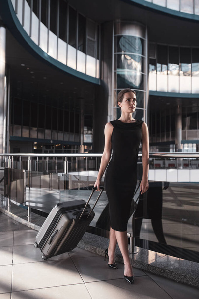 Business woman with a suitcase walking in the airport - Photo, Image