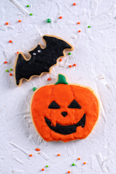 Top view of Halloween festive decorated icing gingerbread sugar cookies on white background with copy space and flat lay layout. - Photo, Image