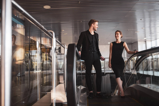 Man and woman using the escalator in the airport - Foto, imagen