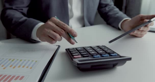 biznesmen pracujący w biurze z kalkulatorem i tabletem cyfrowym. biznesowe raporty finansowe i analiza danych - Materiał filmowy, wideo