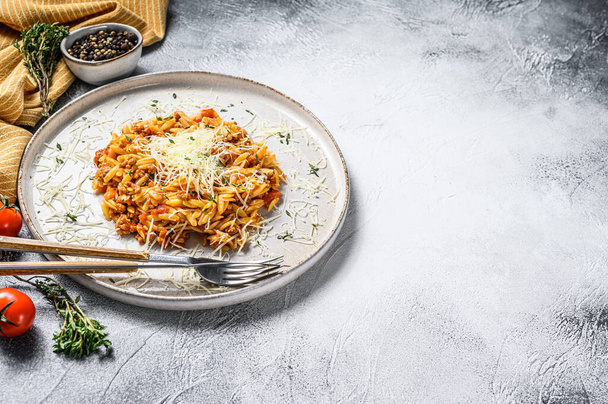Orzo pasta, risone met Bolognese saus en gemalen rundvlees in een bord. Grijze achtergrond. Bovenaanzicht. Kopieerruimte. - Foto, afbeelding