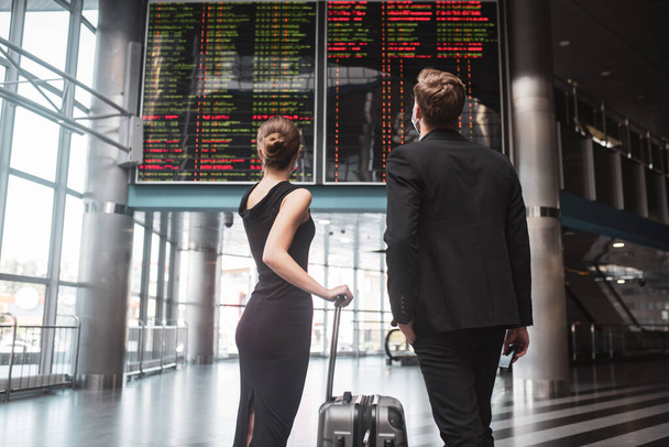 Man and woman looking at the timetable in the airport - Zdjęcie, obraz