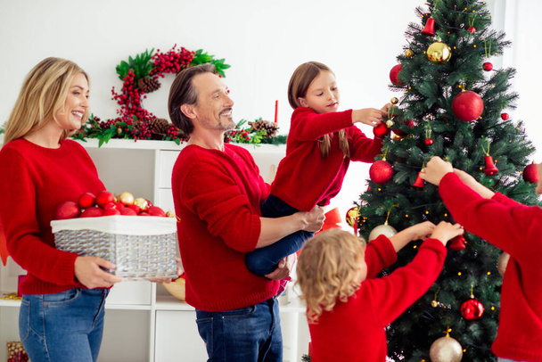 Profile side view portrait of nice attractive big full cheerful cheery family small little kids decorating fir tree having fun spending day Eve Noel in light white apartment house indoor - Valokuva, kuva
