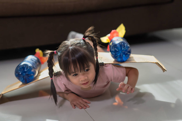 Портрет щасливої азіатської маленької дівчинки, яка грає в костюмі астронавта. - Фото, зображення