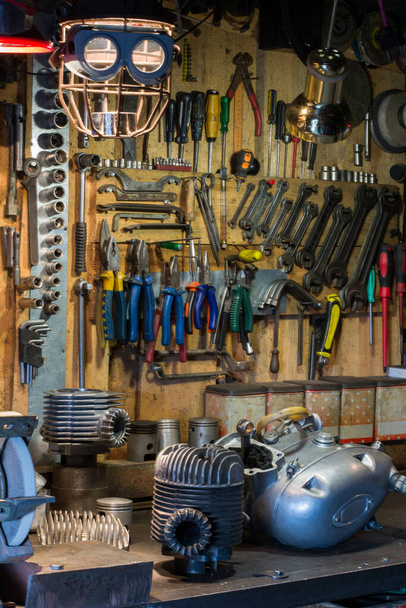 Motorcycle parts and tools on the desktop in the garage - Photo, Image