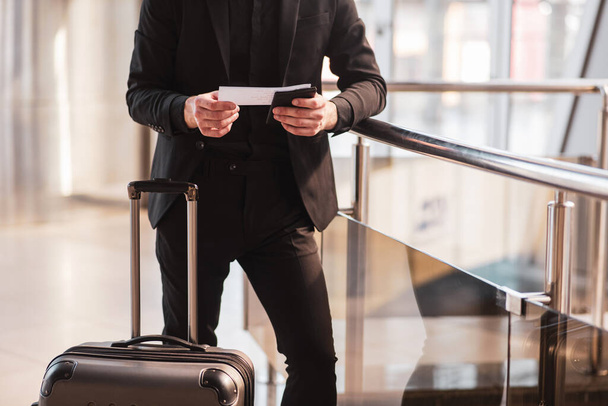 Man checking travel details in his boarding pass - Foto, afbeelding