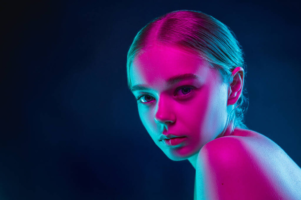 Portrait of female fashion model in neon light on dark studio background. - Φωτογραφία, εικόνα