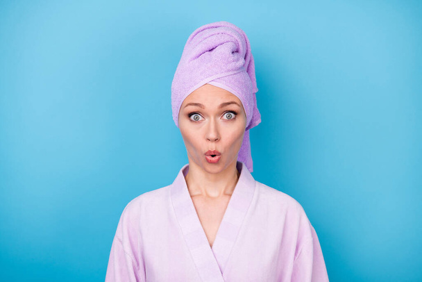 Photo of young woman speechless staring camera wear violet towel turban bathrobe isolated blue color background - Foto, Bild