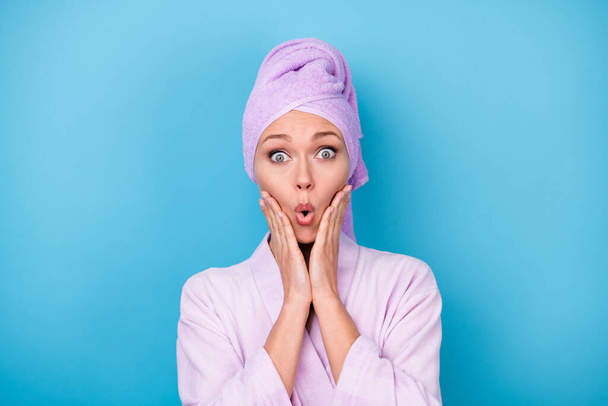 Photo of pretty girl hands cheeks shock expression wear violet towel turban bathrobe isolated blue color background - Foto, Imagen