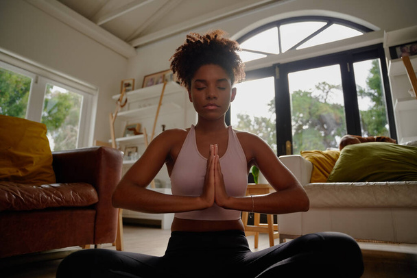 Portrait of young african yogic woman practicing yoga in namaste position and closed eyes - Photo, image
