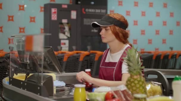 Jonge aantrekkelijke verkoper in uniform intensief werken in de moderne supermarkt. Concept kruidenier - Video