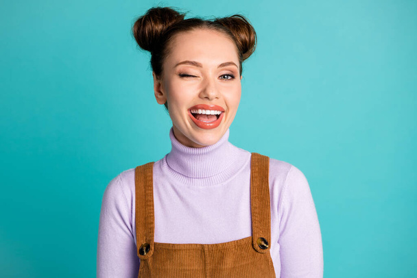 Photo of cheerful friendly nice beaming playful lady girlfriend two buns hairdo glossy lips great amazing time wink one eye open mouth wear fall outfit isolated vivid teal color background - Zdjęcie, obraz