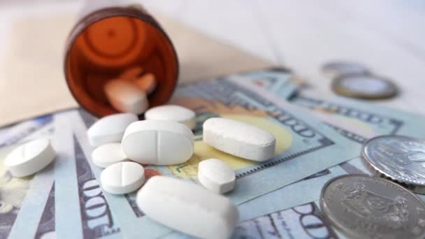 Zdravotní péče koncepce s námi dolar, kontejner a pilulky na stole  - Záběry, video