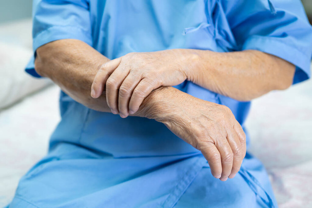Aziatische senior of oudere oude dame vrouw patiënt voelen pijn aan arm en hand op bed in verpleegkundige ziekenhuis afdeling, gezonde sterke medische concept. - Foto, afbeelding