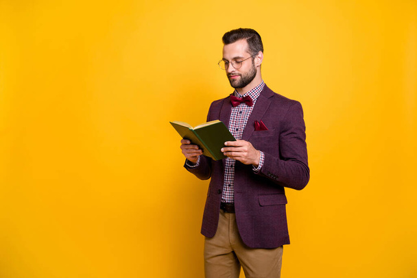 Portrait of his he nice attractive focused intellectual guy reading book academic learning free time knowledge library isolated over bright vivid shine vibrant yellow color background - Фото, изображение