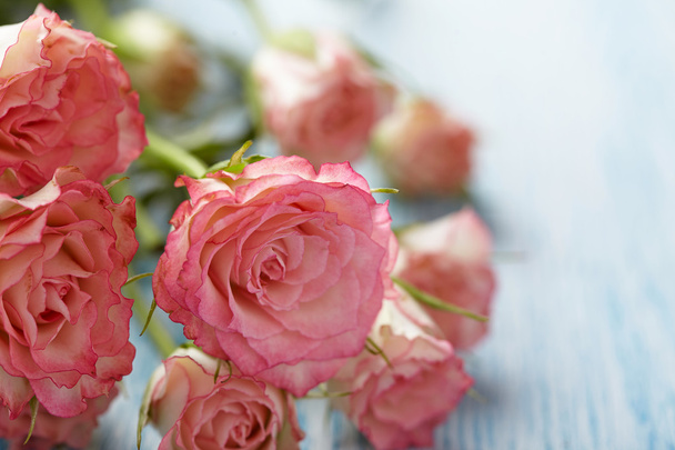 Vaaleanpunaiset ruusut kimppu puinen pöytä
 - Valokuva, kuva