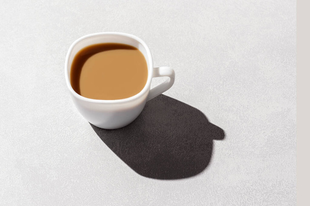 Una taza de café con leche en una mesa gris con una sombra dura con espacio para copiar. - Foto, Imagen