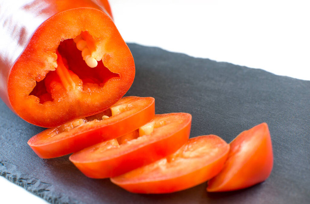 Slices of red pepper lie on a cutting board. Fresh bell pepper - 写真・画像