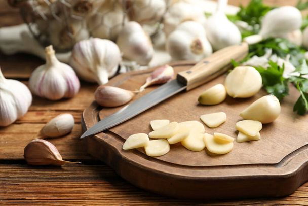 Fresh whole and cut garlic on wooden table. Organic product - Φωτογραφία, εικόνα