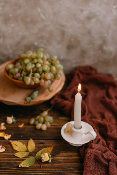 fall still life grape and candle on the wooden table - Fotoğraf, Görsel