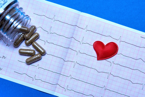 Cardiogram, pills and a toy heart on a colored background. - Photo, Image