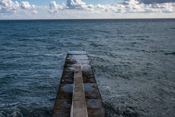 θαλασσογραφία με τυρκουάζ θάλασσα και γκρίζα σύννεφα - Φωτογραφία, εικόνα