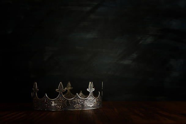 low key image of beautiful queen/king crown over wooden table. vintage filtered. fantasy medieval period - Foto, afbeelding
