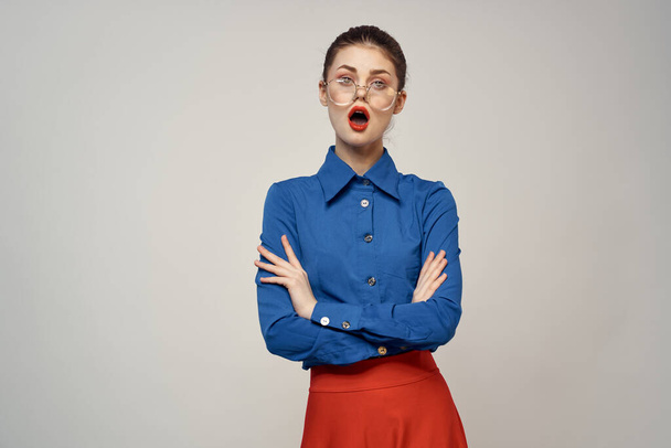 Mavi gömlekli ve kırmızı gözlüklü kadın model. Güzel yüz makyajı stüdyosu. - Fotoğraf, Görsel