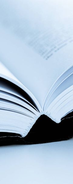 Blauw getinte macro close-up van een open boek, onderwijs en studie - Foto, afbeelding
