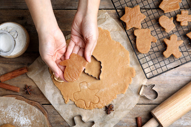 女性は木製のテーブルでクリスマスクッキーを作る,トップビュー - 写真・画像