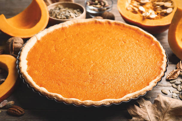 Delicious homemade pumpkin pie on wooden table - Foto, afbeelding