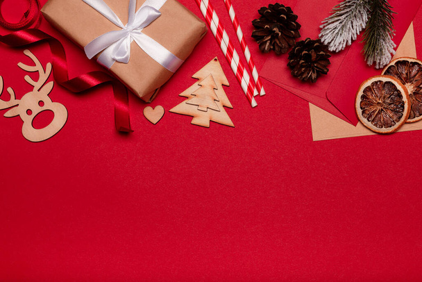 Composition de Noël. Décorations rouges de Noël, coffret cadeau, branches de sapin sur fond rouge. Pose plate, vue du dessus, espace de copie - Photo, image