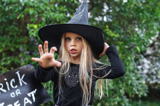 Little girl in witch costume outdoor. Happy Halloween - Foto, immagini