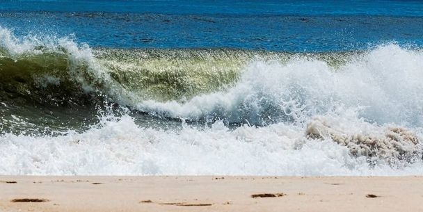 Una ola en el Océano Atlántico se está rompiendo en la playa de la costa de Fire Island Nueva York. - Foto, Imagen
