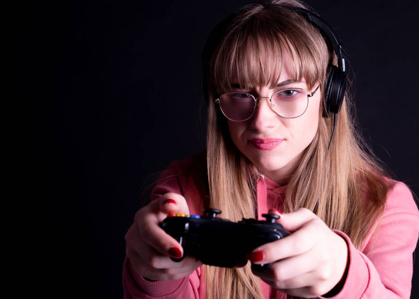 woman with headphones and glasses, with a controller playing the console - Foto, Imagem