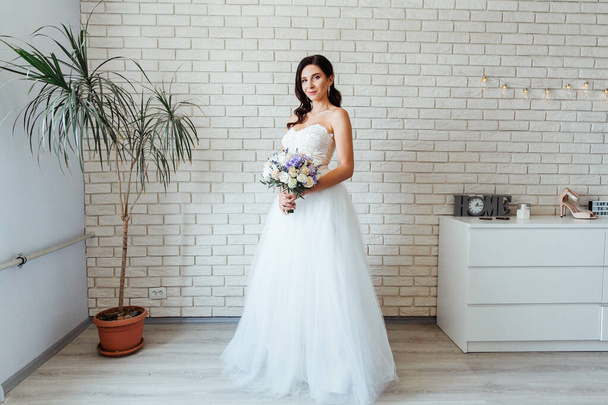 Portrét krásné nevěsty s kyticí v bílých svatebních šatech - Fotografie, Obrázek