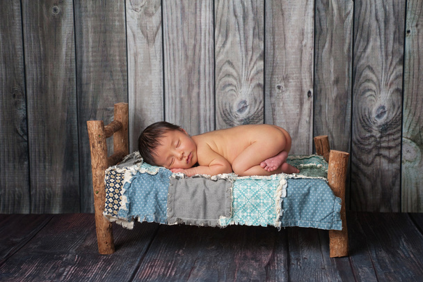 小さなベッドに寝ている生まれたばかりの赤ちゃんボーイ - 写真・画像