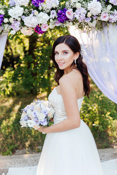 Портрет красивой невесты с букетом в белом свадебном платье - Фото, изображение