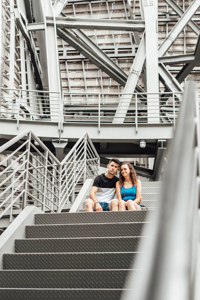 Young couple on an industrial staircase - Fotoğraf, Görsel