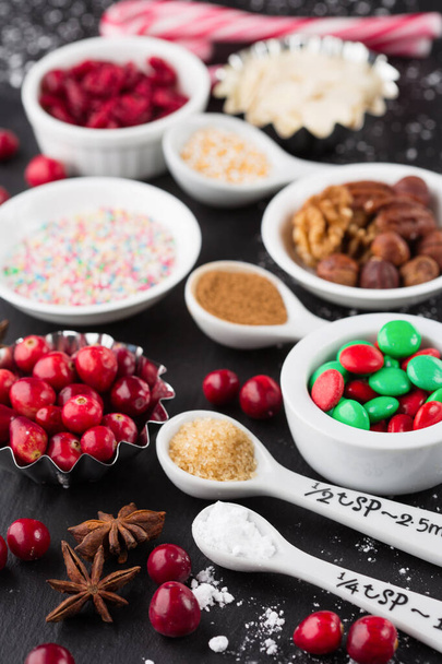 クリスマスのペストリー、クッキーやパイを調理するための成分。黒いテーブルの上でクリスマスベーキングの背景。選択的フォーカス。冬休み時間のコンセプト. - 写真・画像