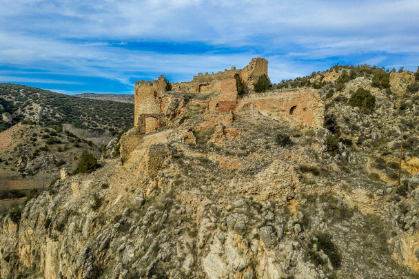 Вид с воздуха на средневековый замок Санта-Кроче (Святой Крест) руины на дороге в Альбаррацин Испания на крутой скале с полукруглым донжоном и частично разрушенными объятиями  - Фото, изображение