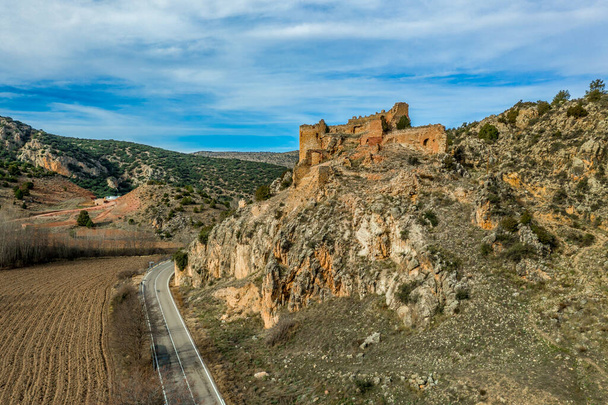 Luftaufnahme der mittelalterlichen Burgruine Santa Croche (Heiliges Kreuz) auf dem Weg nach Albarracin Spanien auf einem steilen Felsen mit einem halbrunden Bergfried und einer teilweise zerstörten Schießscharte  - Foto, Bild