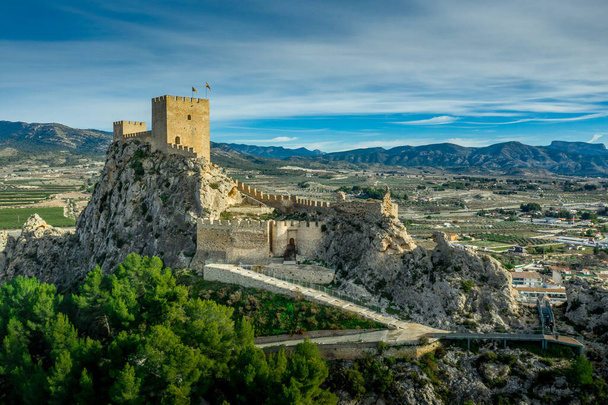 Воздушный вид средневекового восстановленного замка Сакс с двумя прямоугольными башнями и двумя полукруглыми башнями, защищающими ворота вблизи Аликанте, Испания - Фото, изображение