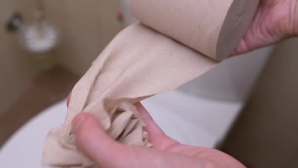 A női kezek behúzzák és letépnek egy darab vécépapírt. Közelkép. Lassú mozgás - Felvétel, videó