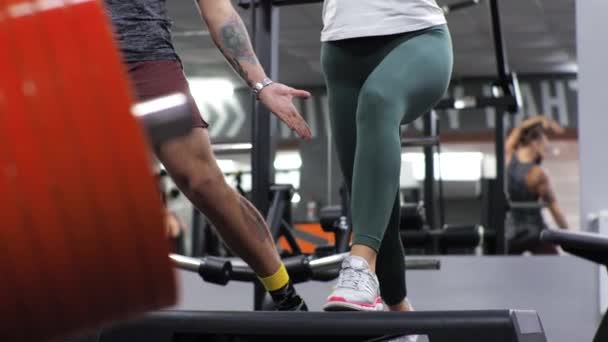 Gym-Unterricht mit einem jungen lustigen Trainer Mann Eine aufstrebende junge Frau stürzt sich - Filmmaterial, Video